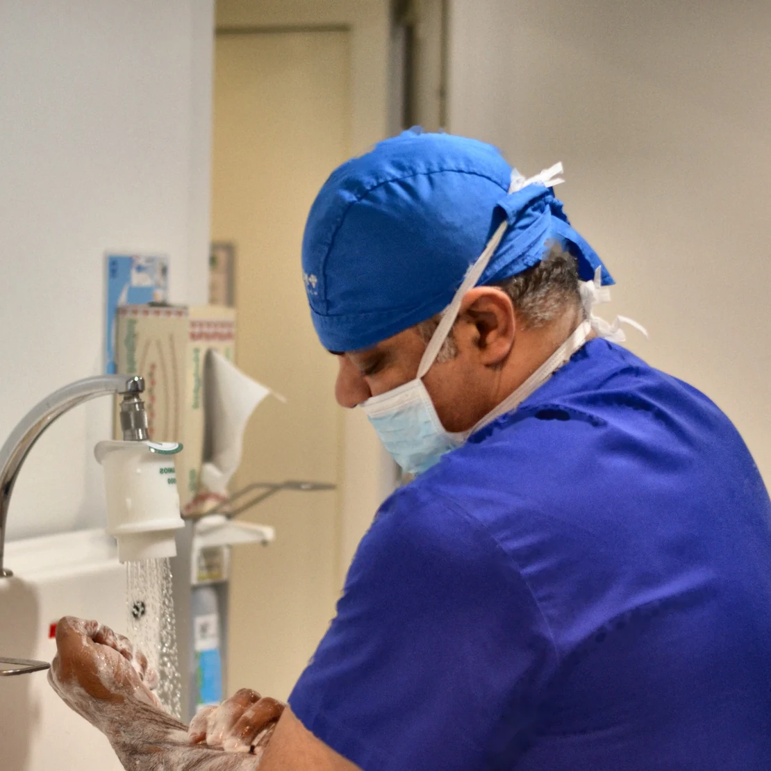Dr. Rachad, în ținută chirurgicală, se spală pe mâini înainte de operație