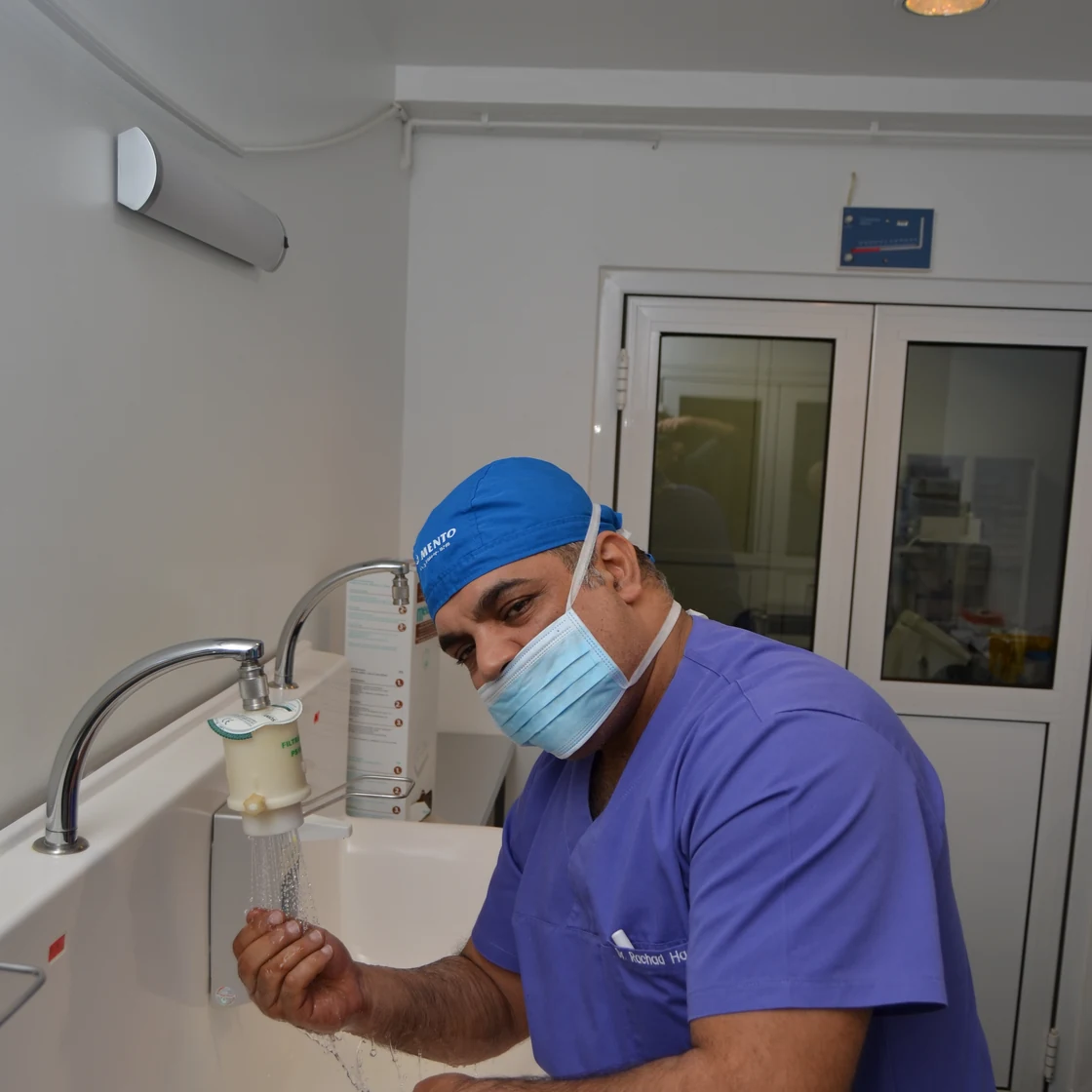 Dr. Rachad se spală pe mâini la chiuveta sterilă, înainte de operație