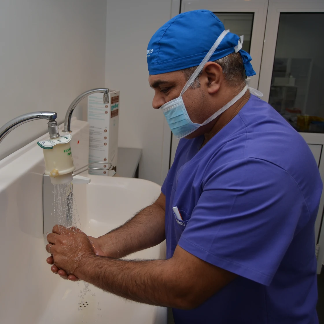 Dr. Rachad, în ținută de operație, la chiuveta sterilă din blocul operator